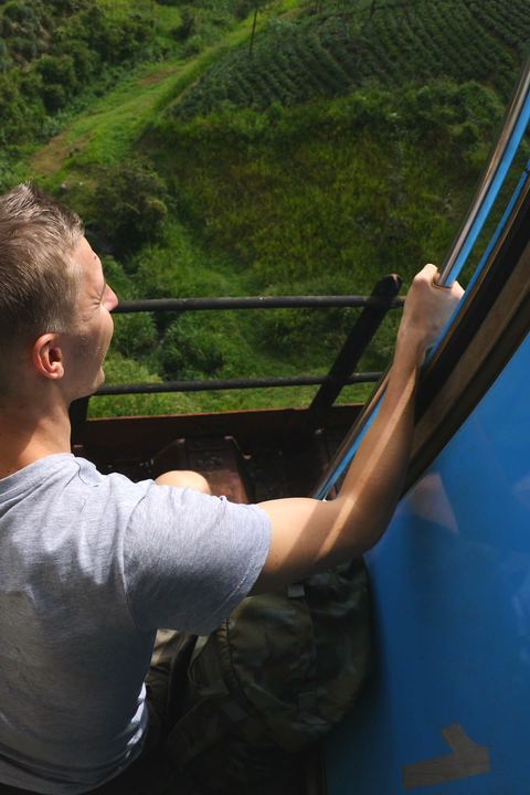 A traveller waving from the blue train in the tea hills